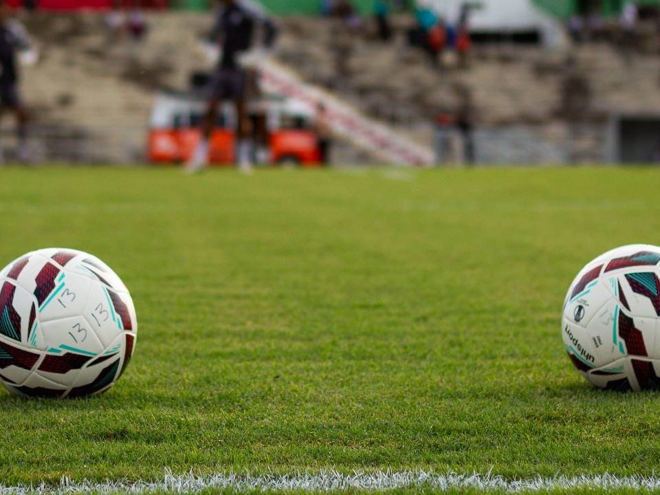 Deux ballons de football sur pelouse